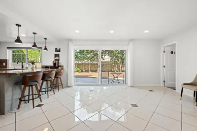 a kitchen and living room with a bar and chairs at Stylish Retreat Large Living Space & Bright Suites in Norwalk