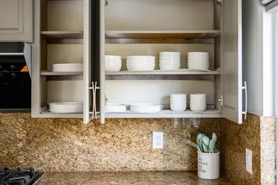 a kitchen cabinet filled with white plates and bowls at Stylish Retreat Large Living Space & Bright Suites in Norwalk