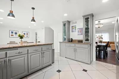 a kitchen with gray cabinets and a dining room at Cozy Full Suites Bright & Private Great Value in Norwalk
