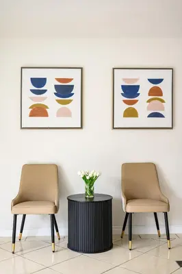 two chairs and a table in a room with two pictures at Cozy Full Suite Private Bathroom Quiet Stay in Norwalk
