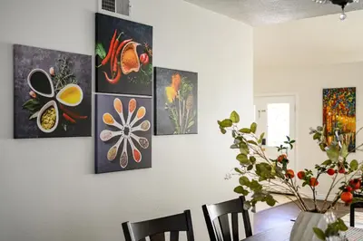 a dining room with four paintings on the wall at Upgraded Queen Suite Private Ensuite Bright Stay in Norwalk