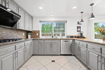 a kitchen with gray cabinets and a large window at Upgraded Queen Suite Private Ensuite Bright Stay in Norwalk
