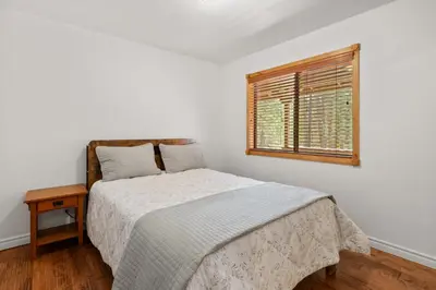 a white bedroom with a bed and a window at Leaf & Needle - Walk to Lake & Village, Picnic Table, Single Story, Fenced Yard in Big Bear Lake
