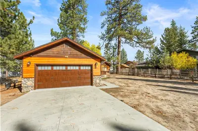 a house with a garage and a fence at Log Cabin Dream - Log Cabin, Walk to Lake, Fireplace, Deck, BBQ in Big Bear Lake