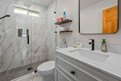 a bathroom with a sink and a toilet and a mirror at Log Cabin Dream - Log Cabin, Walk to Lake, Fireplace, Deck, BBQ in Big Bear Lake