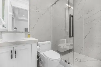 a bathroom with a toilet and a glass shower at Spaulding Ave Farmhouse in Los Angeles