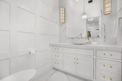 a white bathroom with a sink and a mirror at Spaulding Ave Farmhouse in Los Angeles