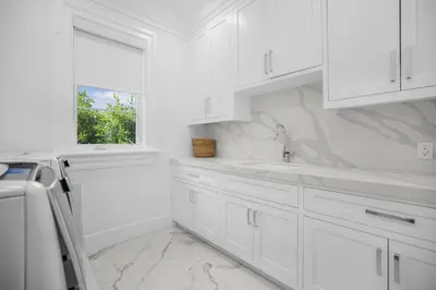 a white kitchen with white cabinets and a window at Spaulding Ave Farmhouse in Los Angeles