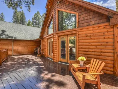 a log cabin with a deck and two chairs at Winter Park Cabin Hot Tub And Game Room in Big Bear Lake