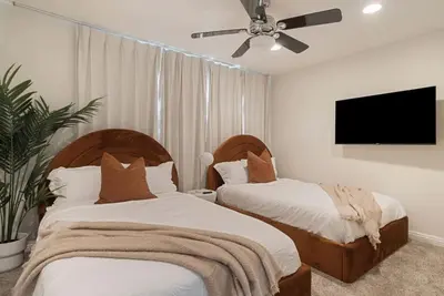 a bedroom with two beds and a flat screen tv at Sunlit Oasis with Heated Pool and Jacuzzi 20 minutes to Disneyland in Placentia
