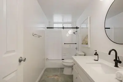 a white bathroom with a shower and a toilet at Sunlit Oasis with Heated Pool and Jacuzzi 20 minutes to Disneyland in Placentia