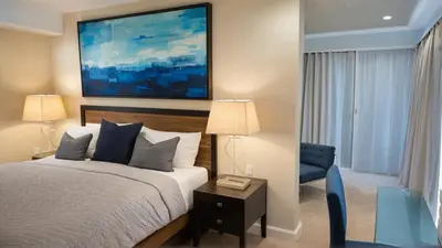 a bedroom with a bed and a blue chair at Modern 4 & 5 BR Townhomes Minutes from Downtown LA in Los Angeles