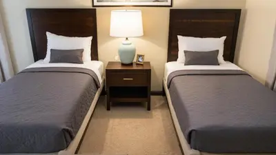 a bedroom with two beds and a lamp on a night stand at Modern 4 & 5 BR Townhomes Minutes from Downtown LA in Los Angeles