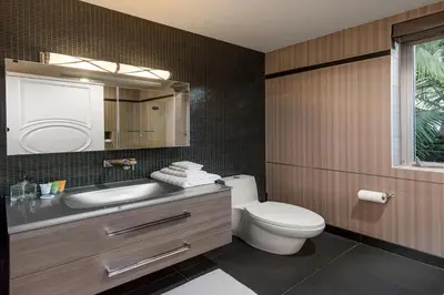 a bathroom with a toilet and a sink and a mirror at Alta Royale in Los Angeles