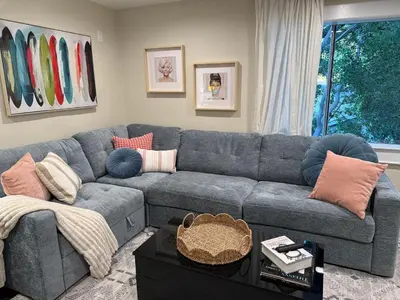 a living room with a blue couch with pillows at Private getaway in Studio City Hills universal in Los Angeles