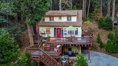 an aerial view of a house with a large deck at Minutes to Lake Arrowhead Village Cozy Secluded Cedar Cove by AvantStay in Lake Arrowhead