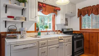 a kitchen with white cabinets and a stove top oven at Minutes to Lake Arrowhead Village Cozy Secluded Cedar Cove by AvantStay in Lake Arrowhead