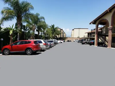 a row of cars parked in a parking lot at Sierra Inn in South El Monte