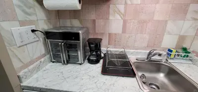 a microwave sitting on a counter next to a sink at The Cozy Corner in Canoga in Canoga Park