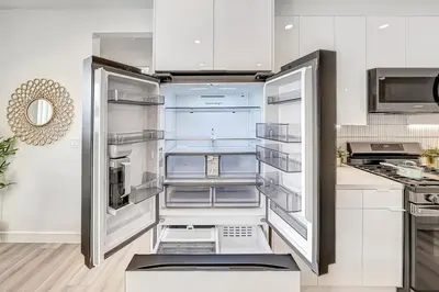 an empty refrigerator with its door open in a kitchen at Modern 3BR with King Bed, Gated Pool and BBQ Oasis in West Valley Area Heliport
