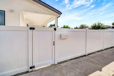 a white fence in front of a house at Modern 3BR with King Bed, Gated Pool and BBQ Oasis in West Valley Area Heliport