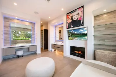 a living room with a fireplace and a white stool at Ultra Luxe Estate With Pool and Stunning 360 LA Views in Los Angeles