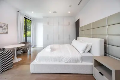 a white bedroom with a bed and a table at Ultra Luxe Estate With Pool and Stunning 360 LA Views in Los Angeles