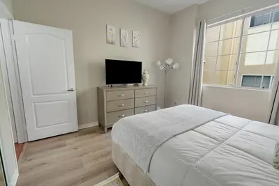 a bedroom with a bed and a television on a dresser at Urban retreat- Quiet comfy 1 bedroom condo near LAX in Los Angeles