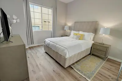 a bedroom with a bed and a television and a window at Urban retreat- Quiet comfy 1 bedroom condo near LAX in Los Angeles