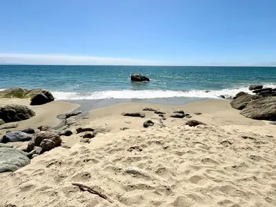 a sandy beach with rocks and the ocean at Malibu Waterfront Gallery with Private Beach Access in Malibu Beach
