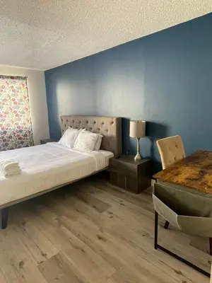 a bedroom with a bed and a blue wall at Modern Apart in Beverly Hills in Los Angeles