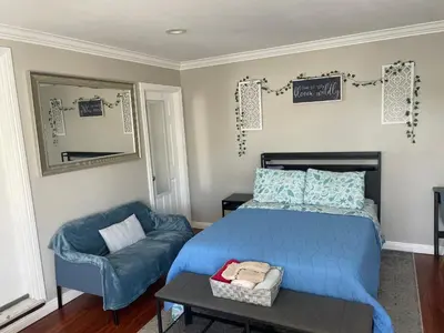 a bedroom with a bed and a chair and a mirror at The stay go in Gardena