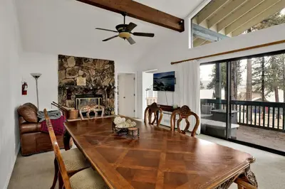a living room with a wooden table and a fireplace at Vivienda De Osos Walk to the Lake Spacious Fawnskin Retreat Chalet in Fawnskin
