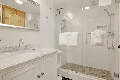 a white bathroom with a shower and a sink at Ours De Ski Chateau at Snow Summit - Big Bear Basecamp Resort Condo w/ Hot Tub in Big Bear Lake