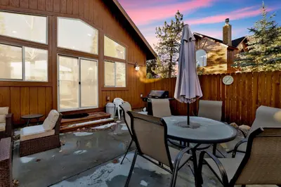 a patio with a table and an umbrella at Morning Star Log Cabin at Big Bear Ultra-Modern Castle Glen Mountain Chalet in Big Bear Lake