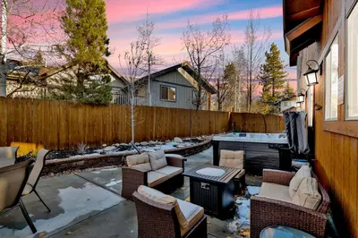 a patio with chairs and a table and a fence at Morning Star Log Cabin at Big Bear Ultra-Modern Castle Glen Mountain Chalet in Big Bear Lake