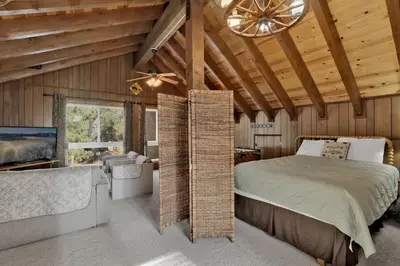 a bedroom in a log cabin with a bed and a chandelier at Crystal Pines at Big Bear Lake Walk to Boulder Bay Park Family-Friendly Retreat in Big Bear Lake
