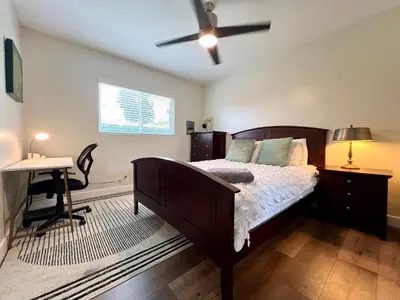 a bedroom with a bed and a desk and a ceiling fan at Golden Downey Designer Abode - Poolside Suite in Downey