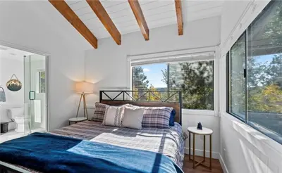a bedroom with a bed and a large window at Relaxing 4 bedroom Mountain Stay in Lake Arrowhead