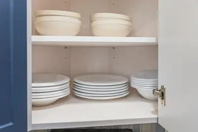 a cupboard filled with white plates and bowls at New 1 BR, King Bed, Laundry In-Unit, Parking in Los Angeles
