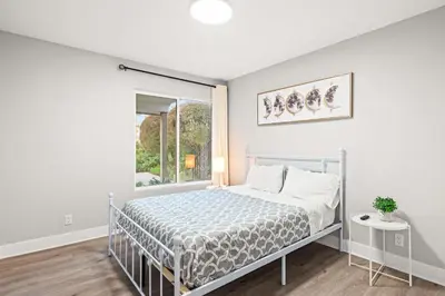 a white bedroom with a bed and a window at Serene Hilltop Oasis Above the City w Private Pool in Hacienda Heights