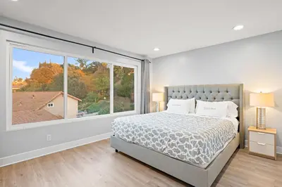 a bedroom with a bed and a large window at Serene Hilltop Oasis Above the City w Private Pool in Hacienda Heights