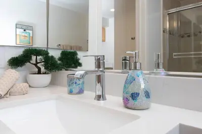 a bathroom with a sink with two bottles on it at Coastal Luxe | Walk to Pier + Free Parking in Los Angeles