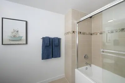 a bathroom with a glass shower with a teddy bear in a bowl at Stylish Santa Monica Apt Free Parking & Wi-Fi in Los Angeles