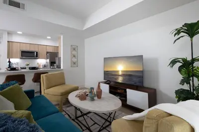a living room with a blue couch and a tv at High-End 1BR Oasis | Walk to Ocean & 3rd Street in Los Angeles