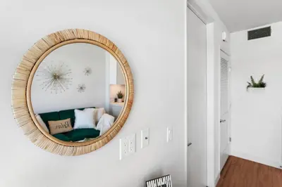 a round mirror on a white wall in a living room at * Breathtaking Place In Santa Monica's Heart * in Los Angeles