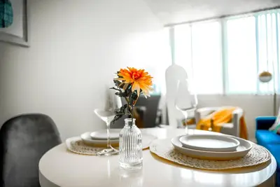a dining room table with plates and a vase with a flower at Oceanview Penthouse Luxury Stay Steps To the Beach in Los Angeles