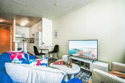 a living room with a blue couch and a flat screen tv at Oceanview Penthouse Luxury Stay Steps To the Beach in Los Angeles