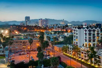 a city skyline at night with buildings and street lights at * Sand & Surf In The Heart Of Santa Monica * in Los Angeles