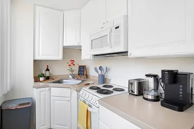 a kitchen with white cabinets and a stove top oven at * Sand & Surf In The Heart Of Santa Monica * in Los Angeles